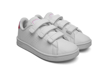 A pair of white children's sneakers with velcro straps and pink heel accents designed for casual...