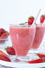 Strawberry smoothie with fresh mint and chia seeds in a glass with white background. Copy space. Close-up. Healthy summer detox drink.