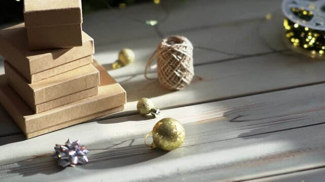 Holiday decor. Packing holiday gifts. Gift boxes, silver bow and Christmas gold balls against the backdrop of the Christmas tree and golden bokeh