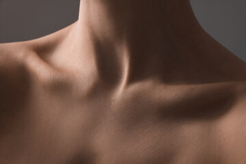 Woman with perfect skin on grey background, closeup