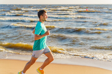 Running along the beach at sunset, a man enjoys the refreshing ocean breeze and the calming waves