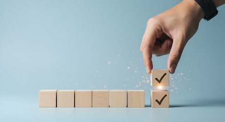 Against a soft blue backdrop, a hand selects a wooden block with a checkmark, visually representing completion, prioritization, or evaluation.