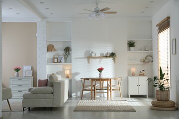 Stylish dining table with chairs and comfortable sofa in room. Interior design