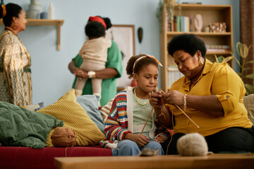 Black Senior Woman Teaching Granddaughter Knitting at Home