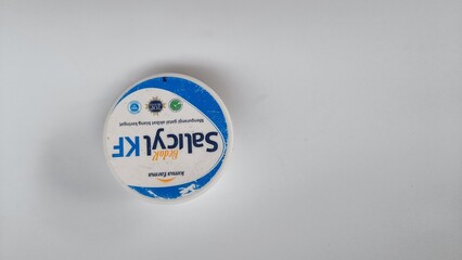 Top view of a generic jar of medicated skin cream or therapeutic balm isolated on a plain white surface.