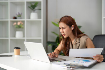 Work Online and Problem Solving. A young professional appears focused and concerned while navigating complex documents in a remote setting.
