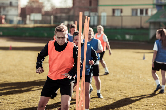 Teen girl soccer players doing agility drills during practice on an outdoor field