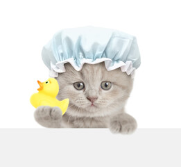 Cute kitten with shower cap on it head looks above blank white banner and shows rubber duck. isolated on white background