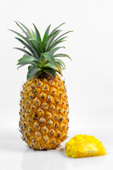 Whole ripe pineapple standing upright beside a juicy sliced piece on white background. Fresh, tropical, and vibrant composition ideal for food, health, or summer-themed designs.