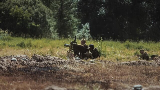Red Army soldier loads heavy Maxim machine gun for defense of trench position before offensive of German army. Great Patriotic War historical reconstruction. Soviet infantry in WWII