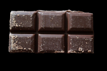 A sleek dark chocolate bar made up of six perfectly aligned squares. Each piece displays a smooth, glossy surface with subtle patterns. 