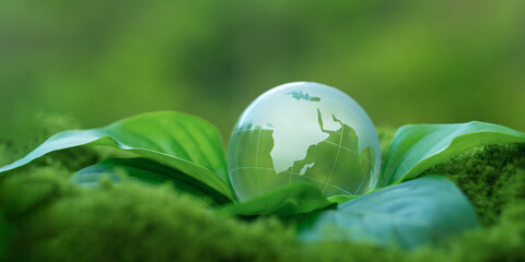 Environmental concept - Crystal Earth on green moss in forest to protect nature. Environmental care, Ecology, Earth Day.