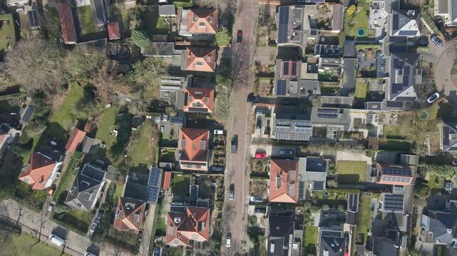 Top down aerial of cars parked in a wealthy neighborhood on a sunny day