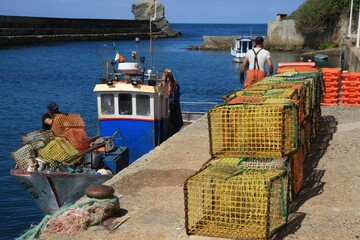 Fishing baskets are neatly stacked on the quay wall