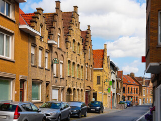 Obraz premium View of typical houses built in Flemish architectural style on summer street of old Belgian city of Diksmuide .