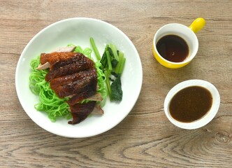 Chinese jade noodles topping roasted duck meat dipping sweet soy sauce on plate 
