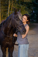 beautiful girl with horse walking in park in summer. equestrian sport