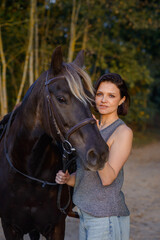 Obraz premium beautiful girl with horse walking in park in summer. equestrian sport