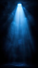 Dramatic blue spotlight illuminates a foggy stage in an empty theater creating an atmospheric and moody ambiance during a quiet moment