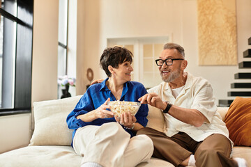 Joyful moments shared between middle aged couple enjoying popcorn at home