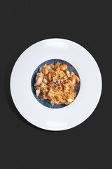 Top-view photograph: seafood fried rice with shrimp, squid, and fish pieces, served in a deep white plate with a blue textured center.