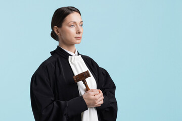 Judge with mallet on light blue background, space for text
