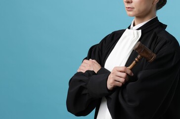 Judge with mallet on light blue background, closeup. Space for text