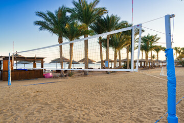 Beautiful beach volleyball court with palm trees and sunset view in a tropical location