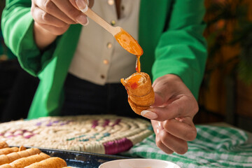 Fototapeta premium Chef pouring sauce on tequeños, venezuelan fried cheese sticks