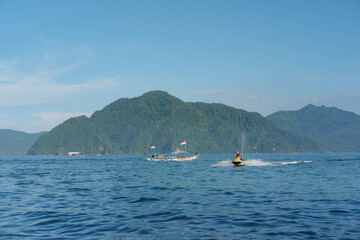 Blue Sea with Speedboat and Mountain Background
