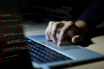 Hands typing on laptop with programming code on screen, representing software development. Perfect...