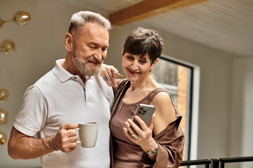 Happy married couple enjoying a cozy moment together at home with a smartphone