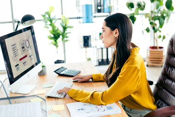 Qualified businesswoman working on a creative project in a bright modern office environment with natural light, stylish decor