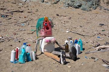 Doll on the beach, made from washed-up waste, tragic symbol of environmental pollution