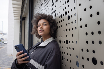 Young woman Checking Phone in Urban Setting