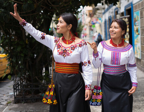 Indigenous otavalo women wearing traditional clothes walking in riobamba city