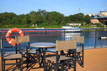 Fototapeta premium Table and chairs on the deck of a river cruise ship on the Rhine river, Germany