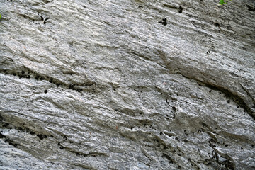 Mining cliff of rough rock cras. Texture of mountain grey stone with high resolution.