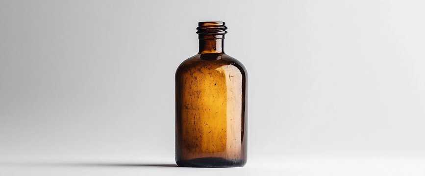 Elegant vintage amber glass bottle in studio setting with soft neutral background