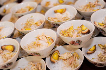 Bowls filled with a mixture of ingredients, including shredded chicken, bean sprouts, sliced boiled eggs with a soy-based outer layer, and white rice vermicelli