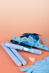 Blue gloves, semaglutide pens and measuring tape arranged on brown gradient background, horizontal health care concept