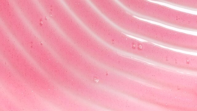 Pink transparent cosmetic gel fluid on the white surface. Macro shot. Waves shower gel texture.