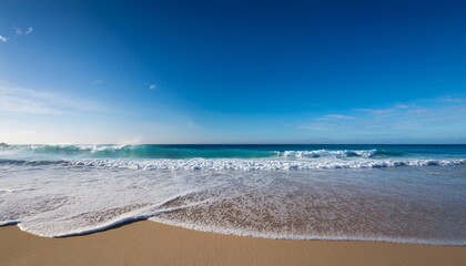 serene ocean view with gentle waves lapping against a sandy beach under a clear sky