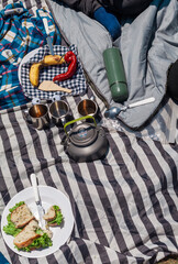 Young family camping on a hilltop with valley views. Pitching a tent, cooking outdoors, drinking coffee, and playing games. Summer adventure with full backpacking gear