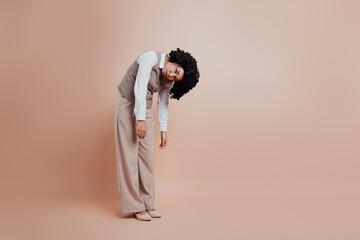 Businesswoman in Elegant Formalwear Posing Expressively Against a Beige Background