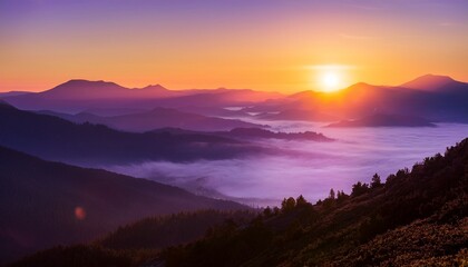 Obraz premium scenic purple sunrise over majestic mountain range landscape with fog and bright sunlight