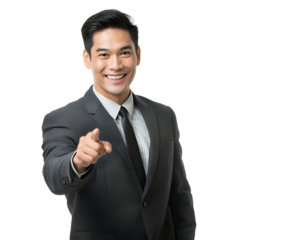 An asian businessman in a suit points, offering a friendly and direct gesture to the viewer.