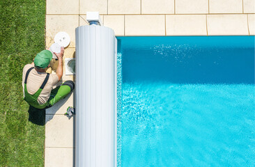 Pool Maintenance Being Performed on a Sunny Day in a Backyard With Clear Water and Green Grass