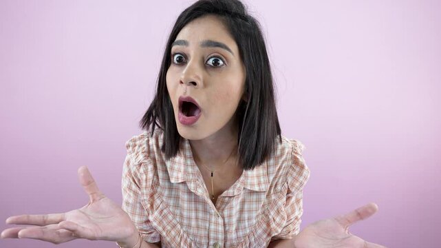 woman looking at the camera with shocked face expression, open mouth, and eyes are wide open
