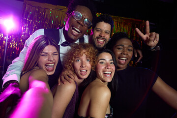 Cheerful friends taking selfie at nightclub party